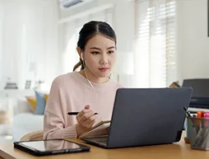 A woman intently studying at her laptop.