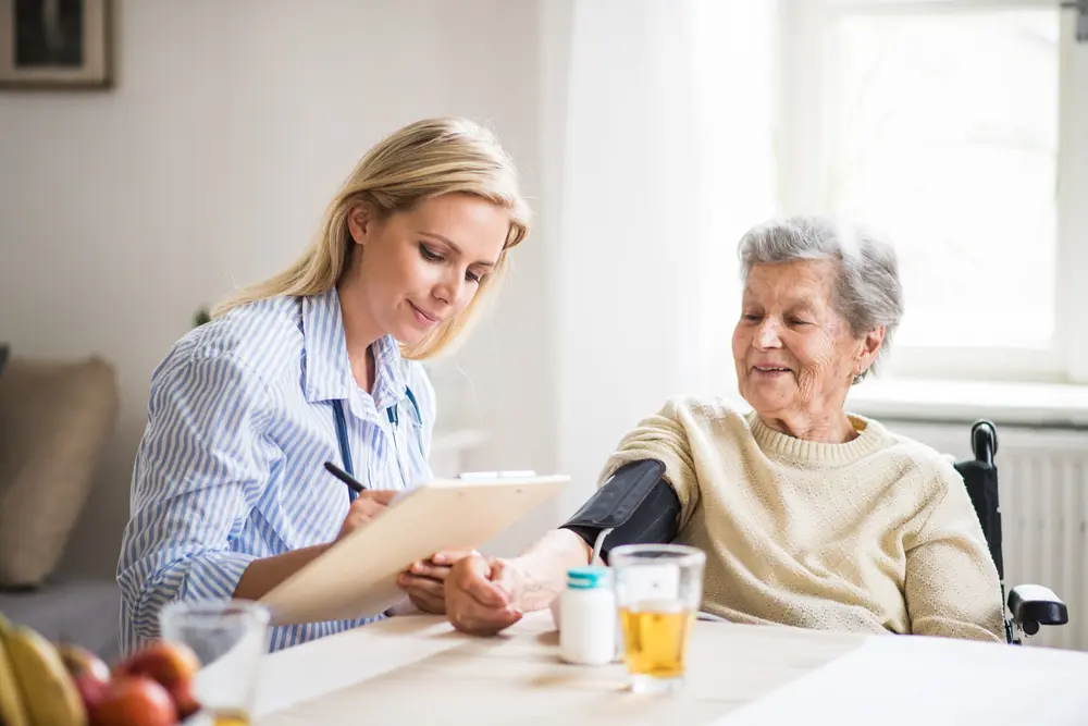 A nurse taking an elderly woman's blood pressure.