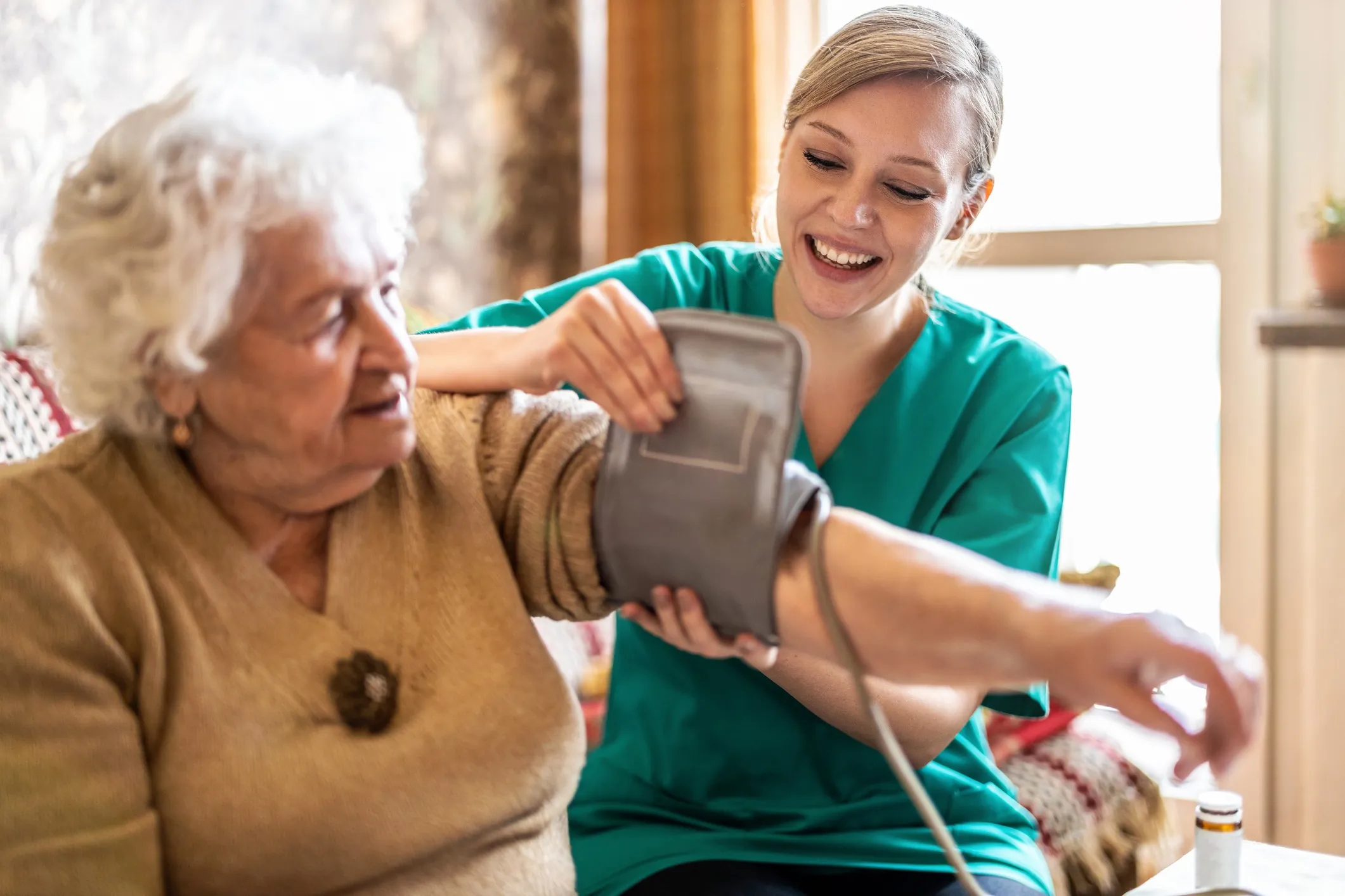 Home nurse taking the blood pressure of a client.