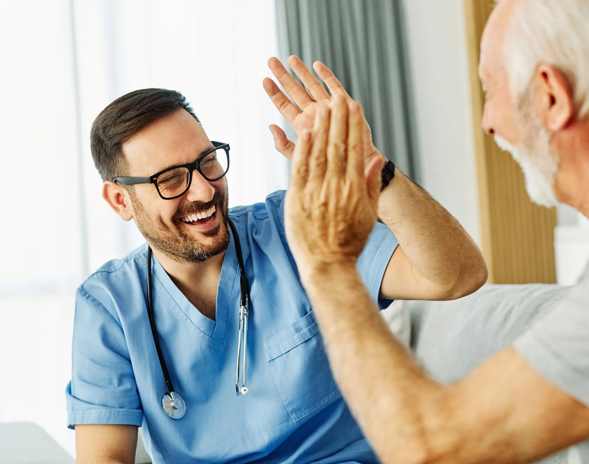 Male nurse high fiving elderly man.