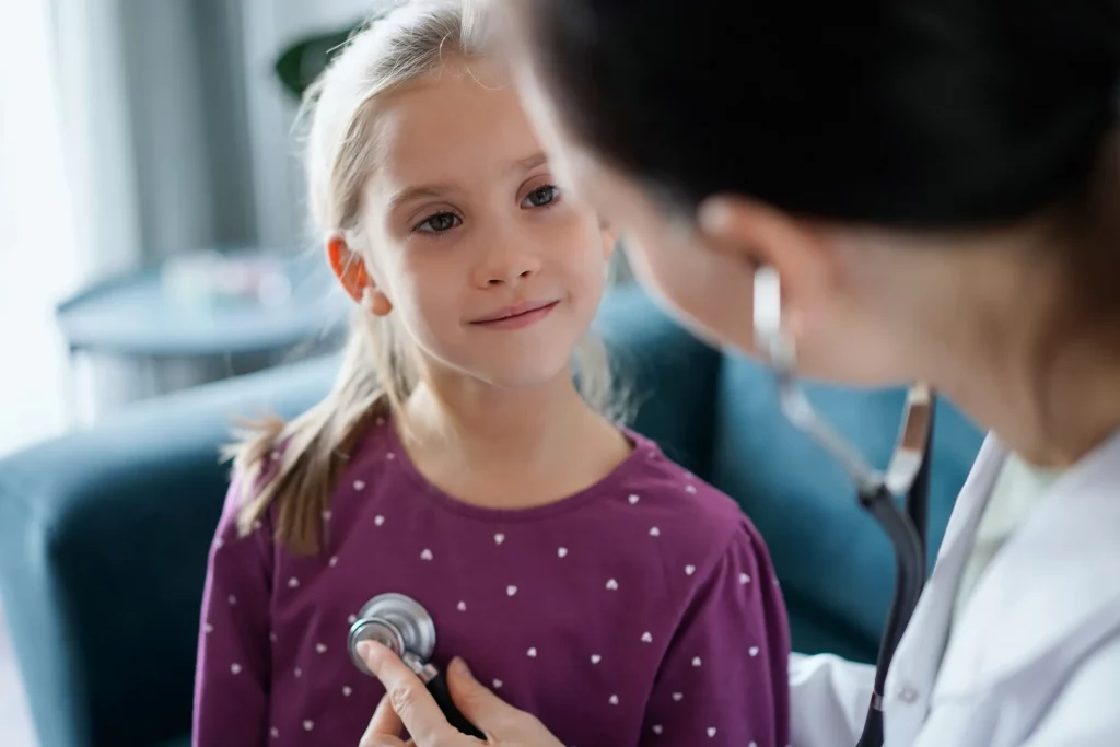 A young girl getting her heart listened to.