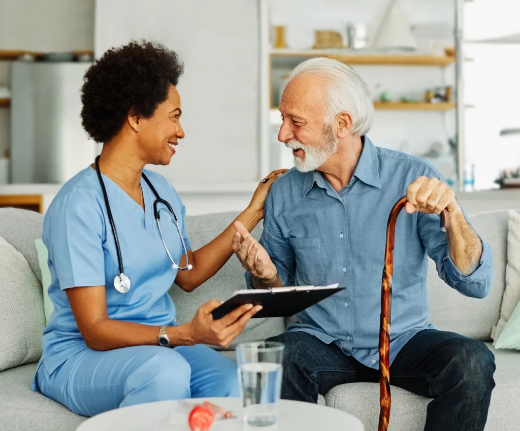 Black female nurse discussing healthcare plan with elderly man.