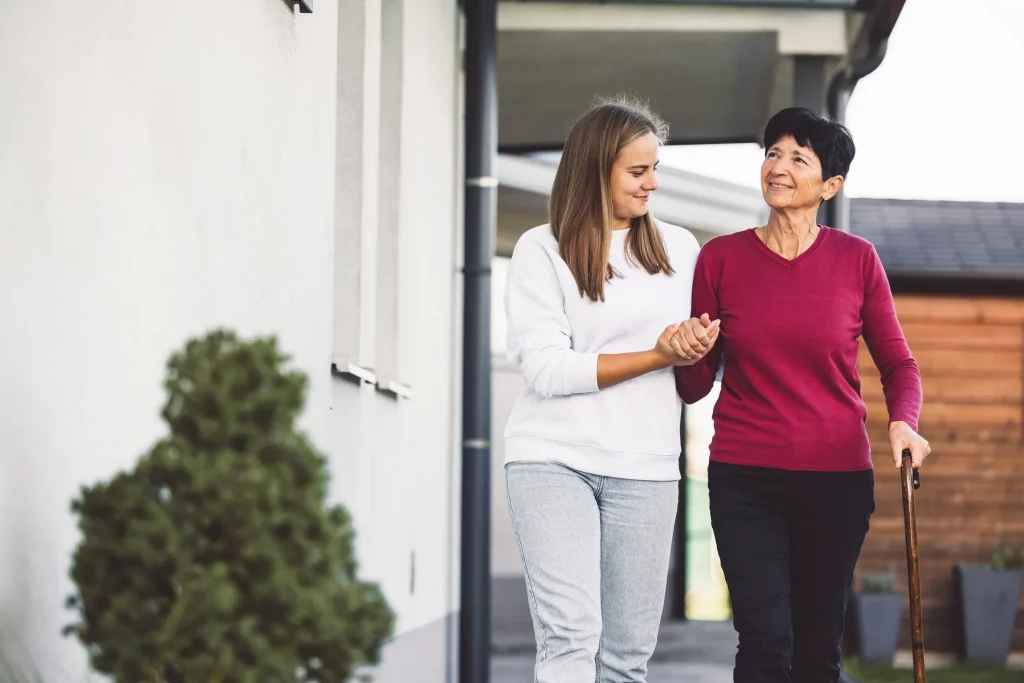 home care aide walking with an elderly woman.