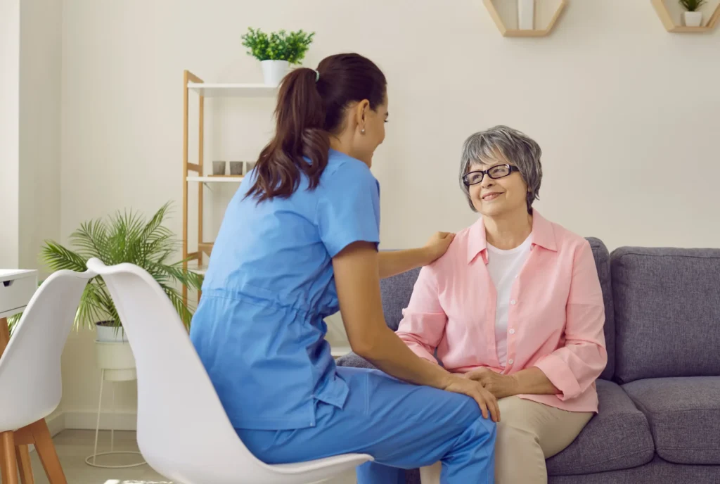 A smiling elderly woman looking at her home health aide.